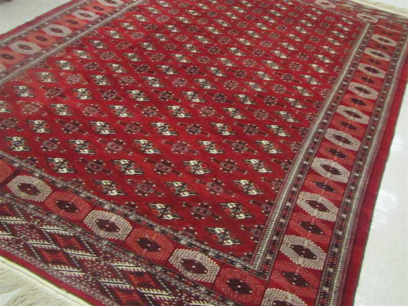 Appraisal: AFGHAN TURKOMAN CARPET repeating columns of geometric gols on red