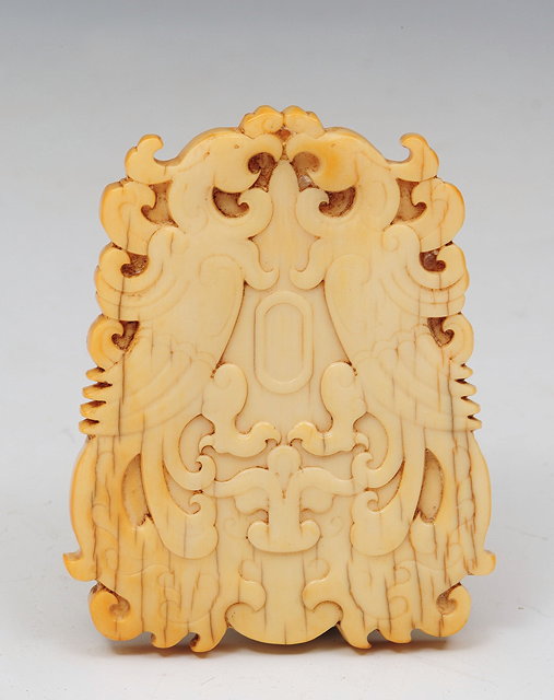 Appraisal: A CHINESE CARVED IVORY PENDANT each side decorated with a