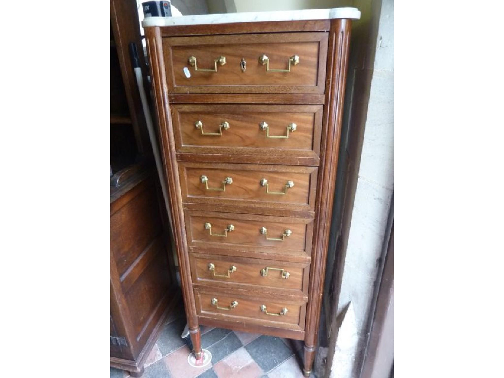 Appraisal: A continental walnut chest fitted with six long drawers flanked