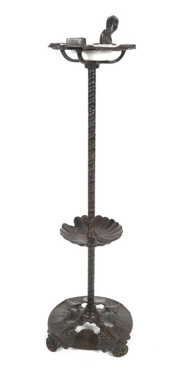 Appraisal: This tall cast-iron ashtray stand contains a glass ashtray that