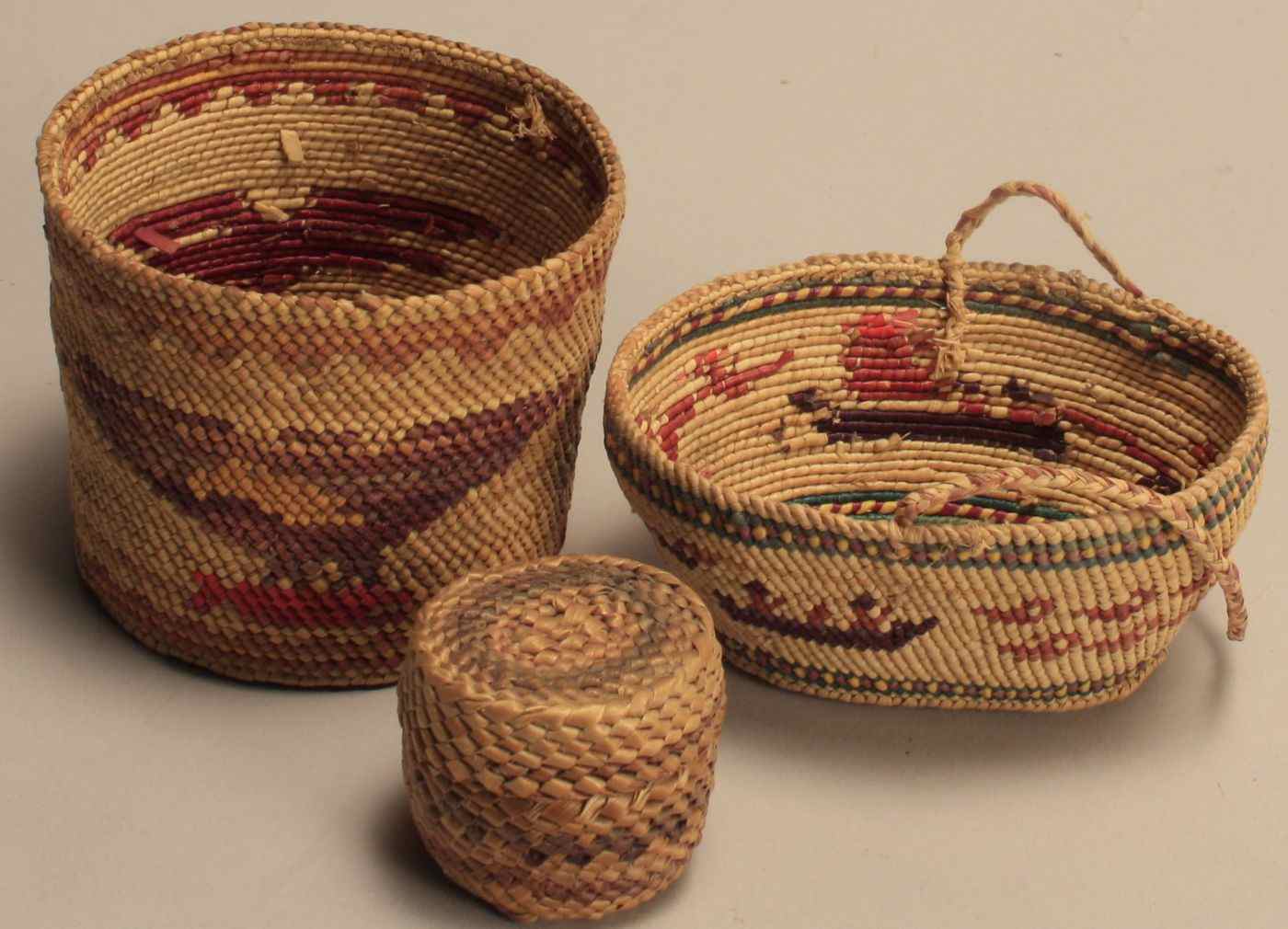 Appraisal: THREE NORTHWEST COASTAL INDIAN BASKETSCirca Miniature cylindrical basket in green