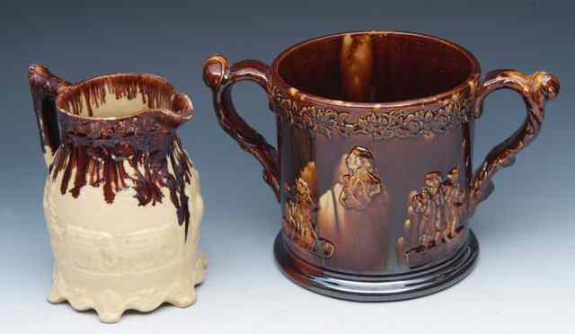 Appraisal: A TH CENTURY BROWN GLAZED POTTERY LOVING CUP with sprigged