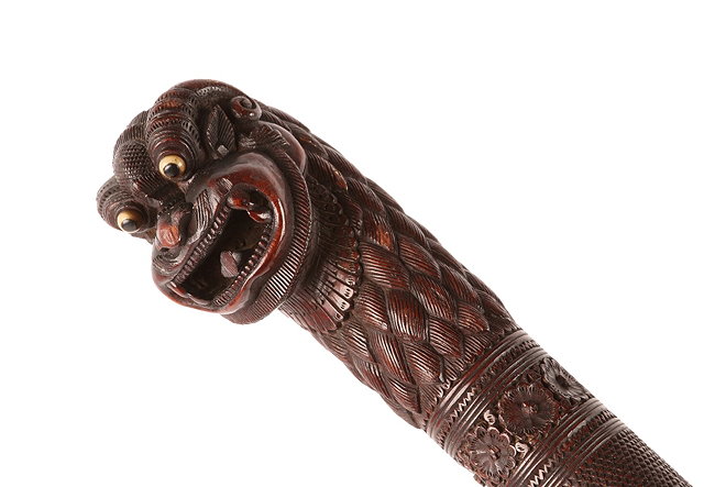 Appraisal: A BURMESE CARVED HARDWOOD WALKING STICK with 'Yuli' head handle