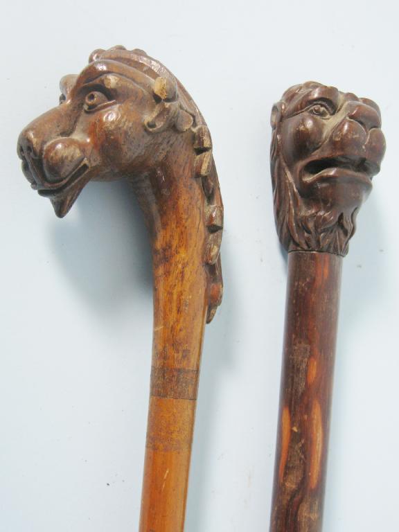 Appraisal: Two Walking Sticks the handles carved as lions heads