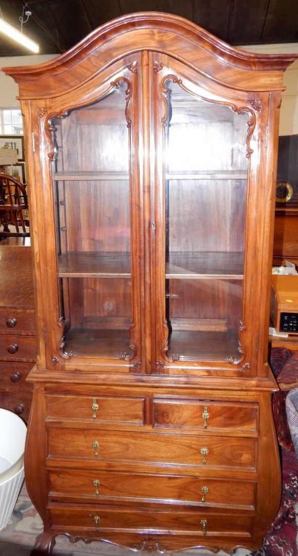 Appraisal: A Continental chestnut bombe display cabinet on chest the domed