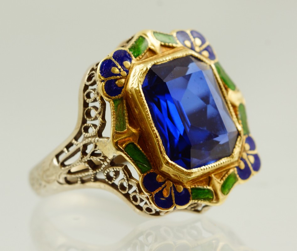 Appraisal: K WG filigree enameled ring with emerald cut blue stone