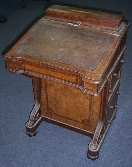 Appraisal: A Victorian walnut Davenport with fitted stationery compartment above a