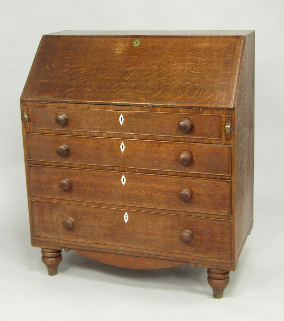 Appraisal: A George III oak bureau the fall flap opening to