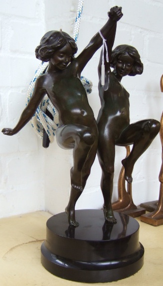 Appraisal: A patinated bronze figure group th century modelled as two