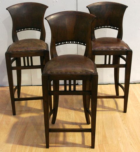 Appraisal: A set of three stained pine and leather upholstered chairs