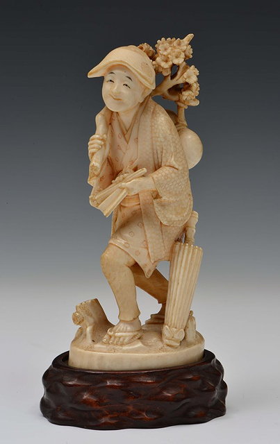 Appraisal: A JAPANESE IVORY OKIMONO a traveller with fan and a