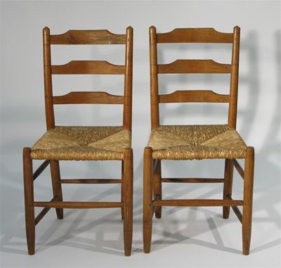 Appraisal: A pair of rush seated ash ladderback chairs designed by