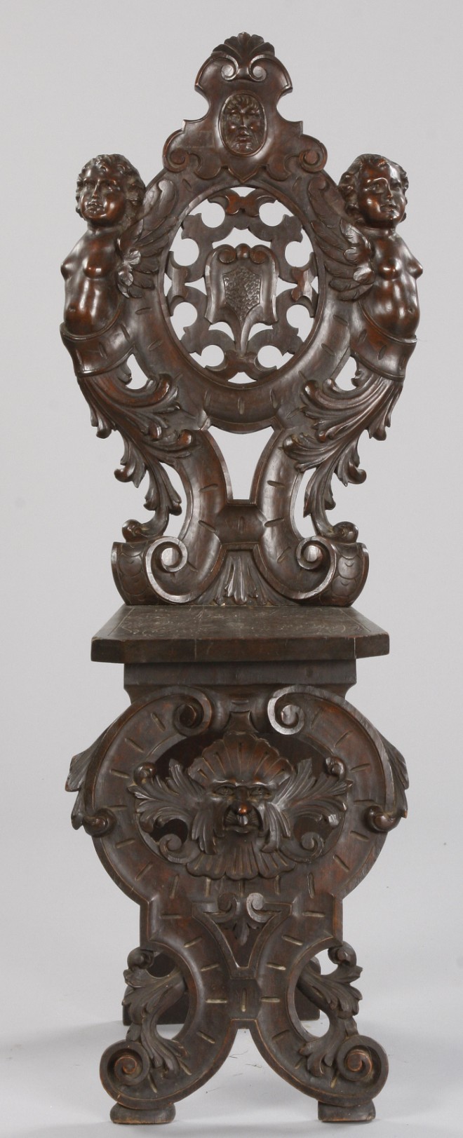 Appraisal: Walnut pierced carved medallion back rest flanked by cherubs over