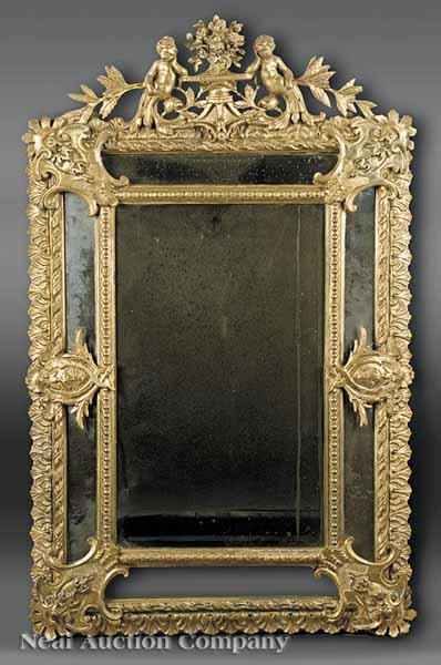 Appraisal: An Antique Louis XIV-Style Carved Giltwood Cushion Mirror the crest