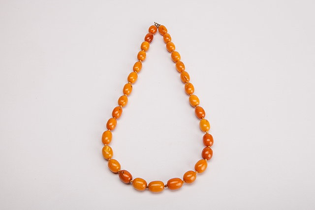 Appraisal: AN AMBER BEAD NECKLACE oval butterscotch beads varying in colour