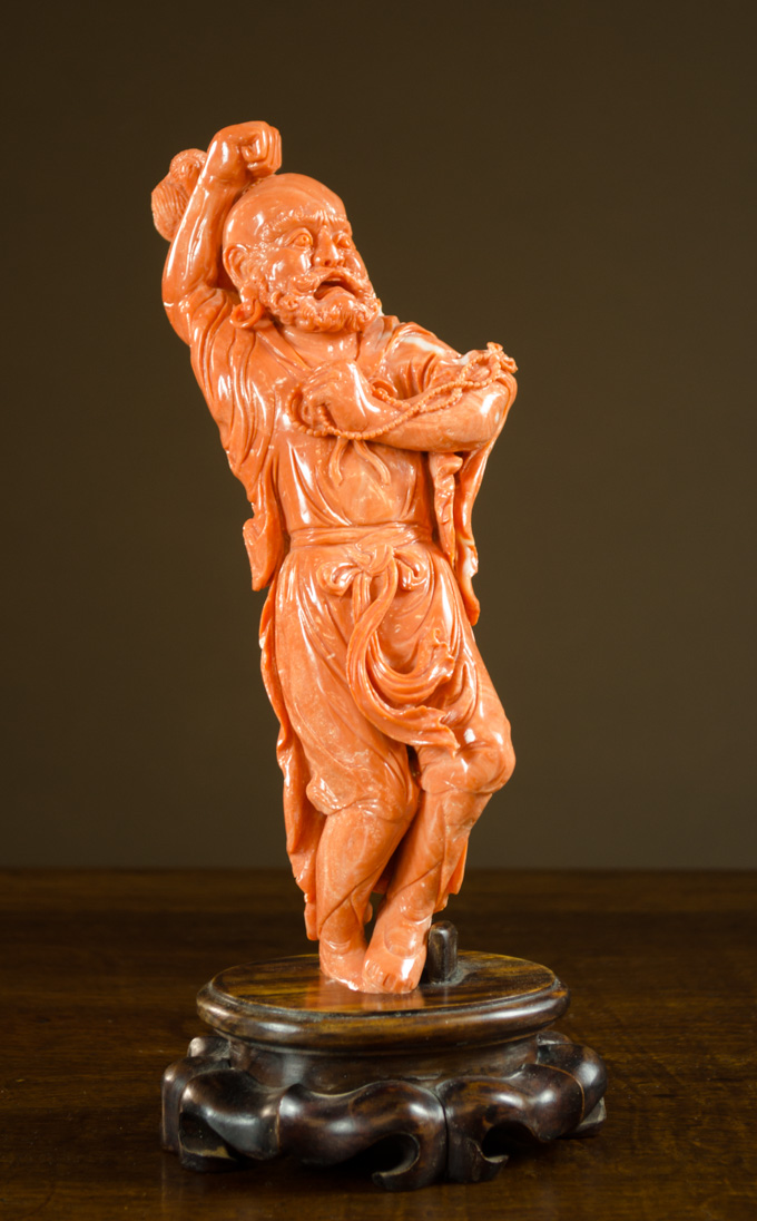 Appraisal: CHINESE CARVED CORAL FIGURE in a red orange color depicting