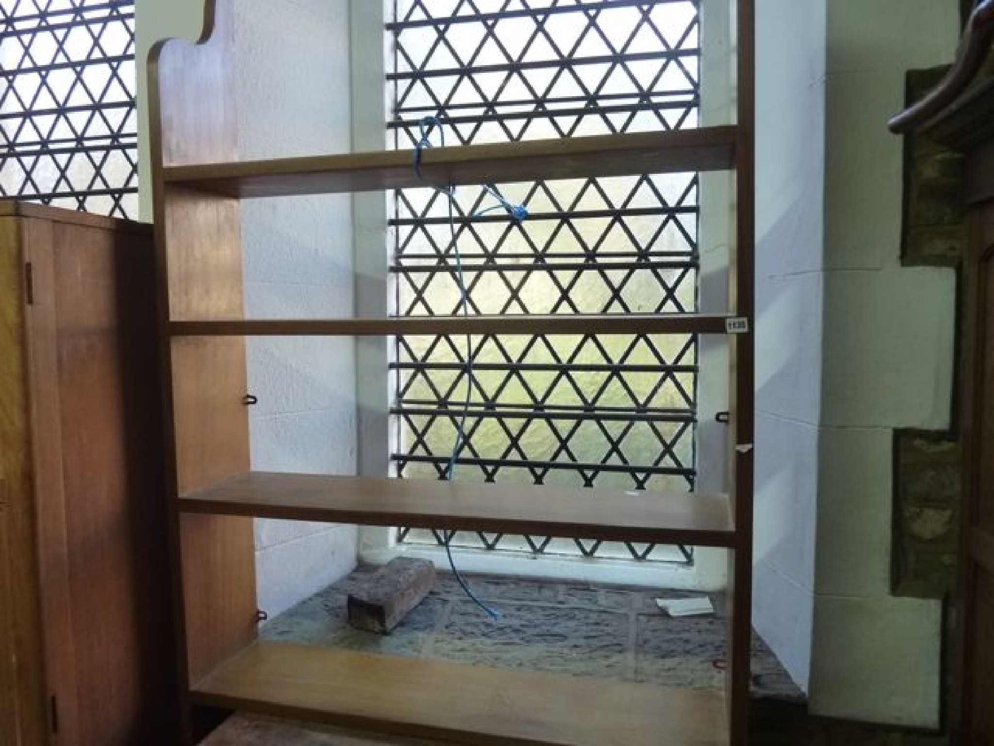 Appraisal: A hardwood hanging bookshelf of four shelves within a shaped