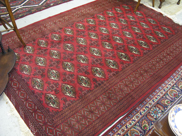 Appraisal: AFGHAN BOKHARA CARPET repeating columns of Turkoman gols on red