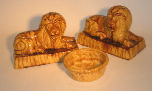 Appraisal: THREE PIECES AMERICAN TH CENTURY POTTERY Pair of recumbent lions