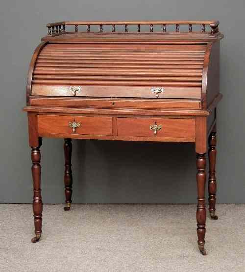 Appraisal: A late Victorian walnut cylinder topped desk the tambour shutter