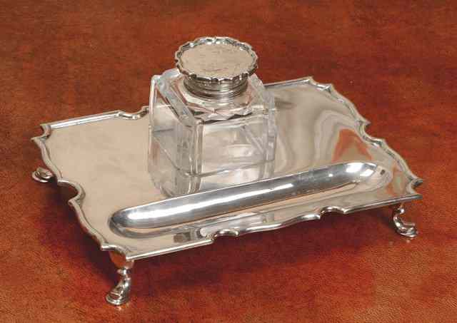 Appraisal: AN EDWARDIAN SILVER DESK STAND rectangular with shaped sides central