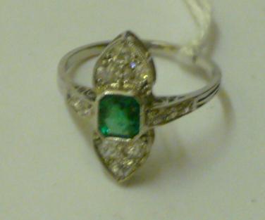 Appraisal: AN EMERALD AND DIAMOND RING the central canted oblong cut