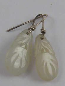 Appraisal: A pair of Chinese carved jade earrings with white metal