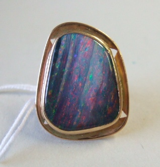 Appraisal: A gold ring mounted with an irregular black opal doublet