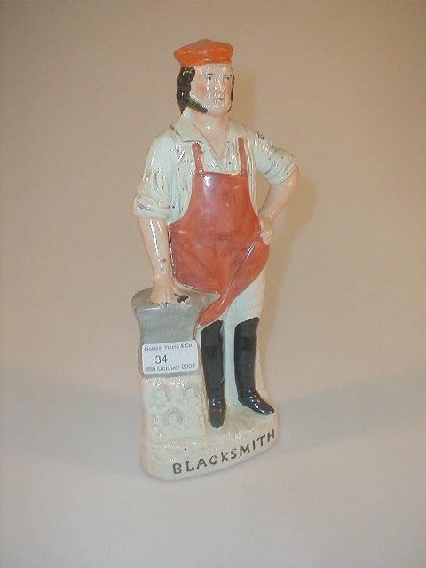 Appraisal: A thC Staffordshire Pottery figure of a blacksmith standing beside