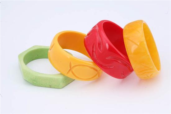 Appraisal: FOUR CARVED BAKELITE BRACELETS Red w yellow w mottled yellow