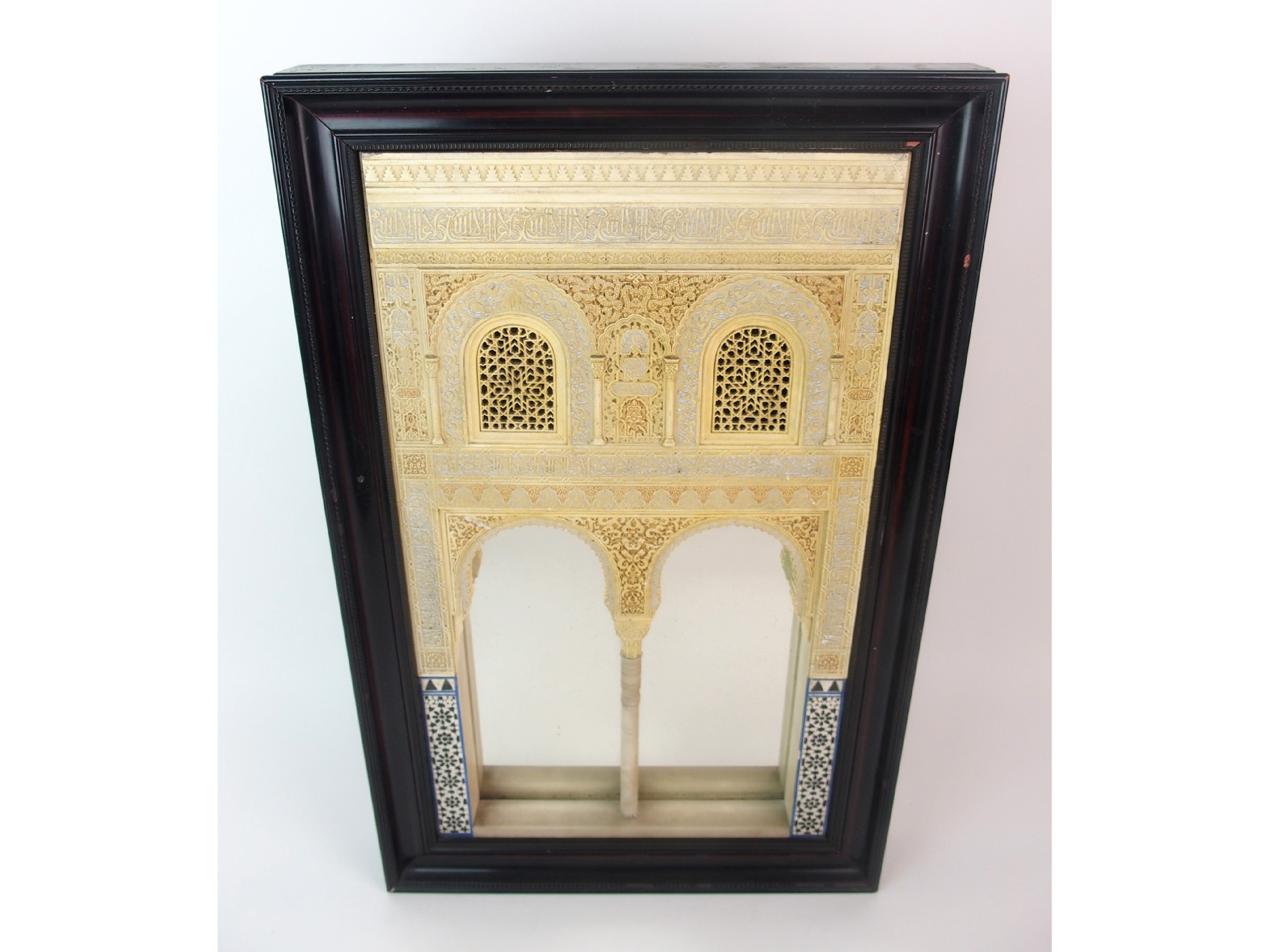 Appraisal: A painted plaster and alabaster Alhambra wall mirrorwith architectural facade