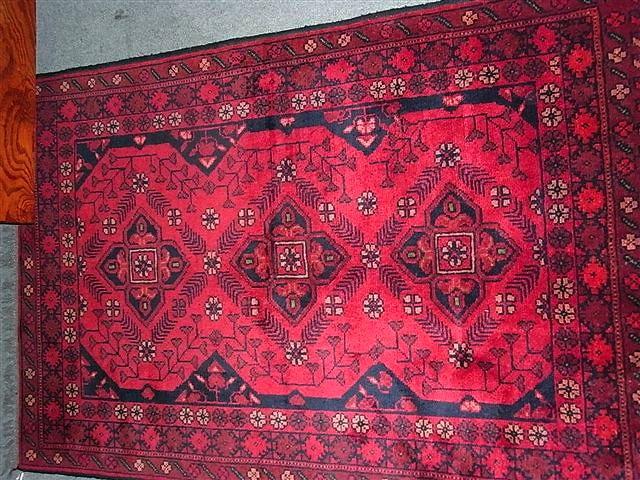 Appraisal: A SIMILAR TURKISH RED GROUND RUG with three medallions x