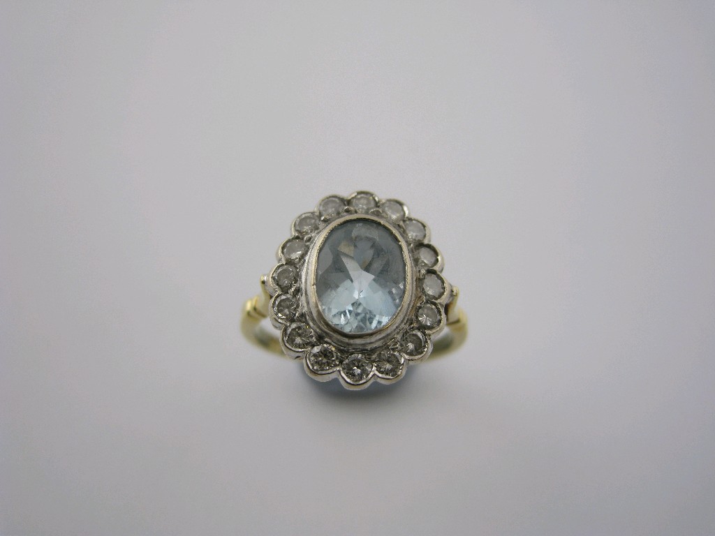 Appraisal: An Aquamarine and Diamond Cluster Ring the central oval-cut aquamarine