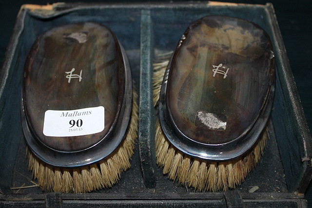 Appraisal: A CASED PAIR OF SILVER BACKED BRUSHES a cased set