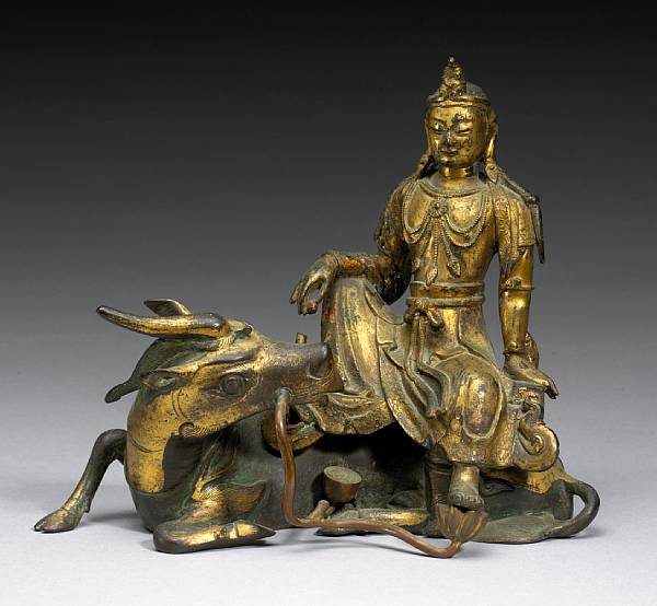 Appraisal: A bronze figure of Guanyin seated on a qilin th