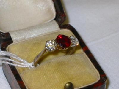 Appraisal: A RING set with ruby flanked by two diamonds approximate