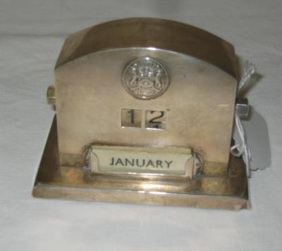 Appraisal: A PERPETUAL DESK CALENDAR of domed oblong form with applied