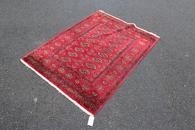 Appraisal: A WINE GROUND BELOUCHI STYLE RUG x cm together with