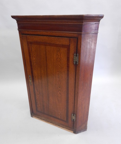 Appraisal: An early thC oak and mahogany crossbanded corner cabinet with