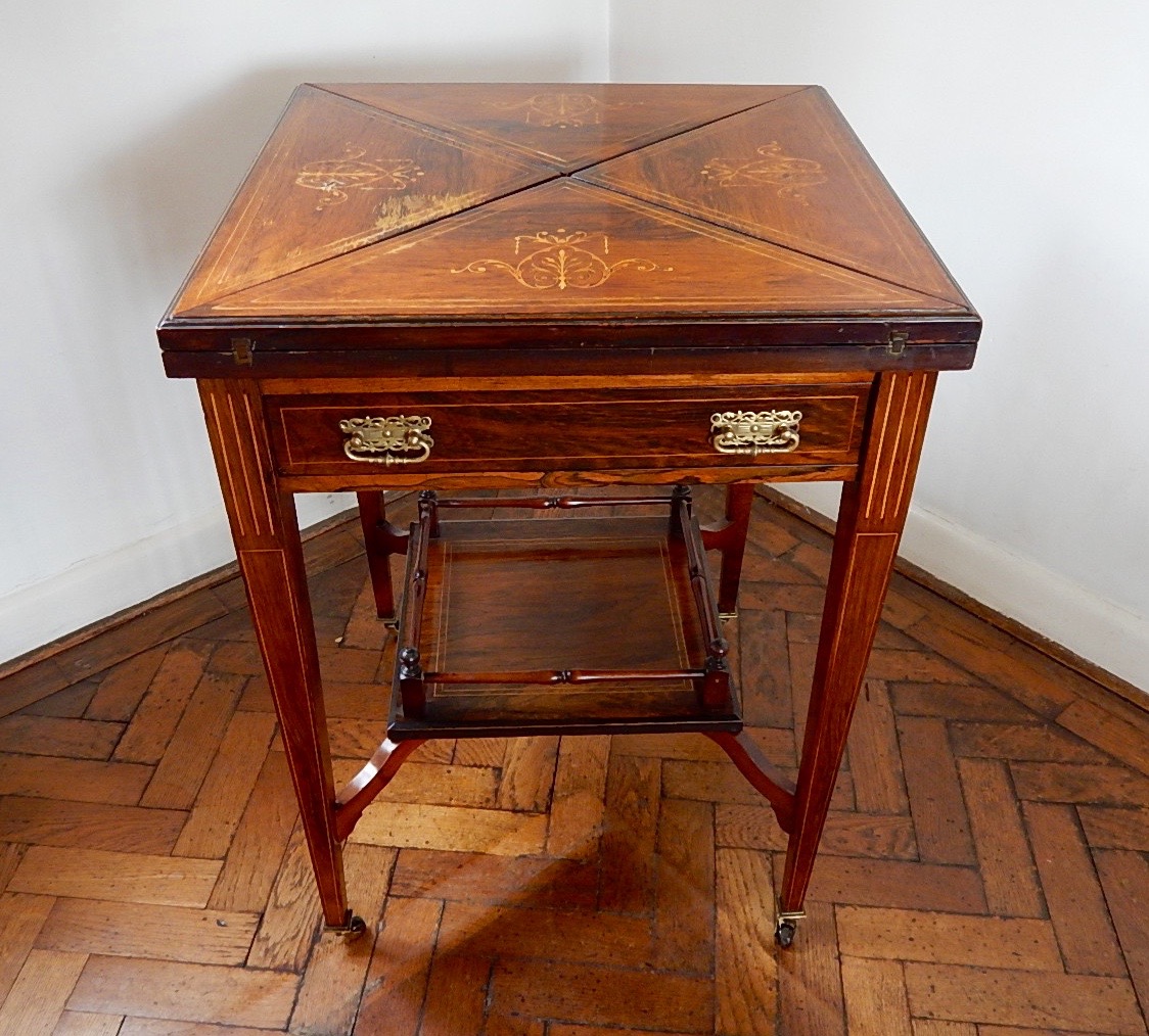 Appraisal: An Edwardian inlaid rosewood envelope top card table fitted with