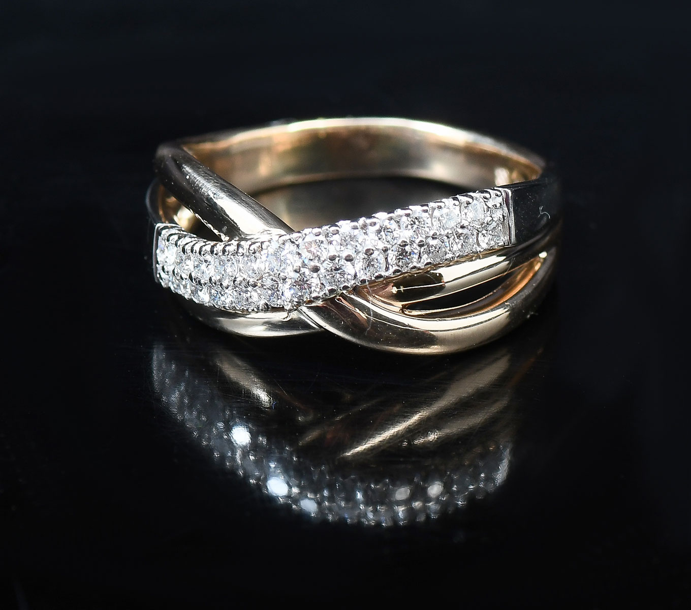 Appraisal: TONE K CROSS-OVER DIAMOND RING K yellow gold ring contains