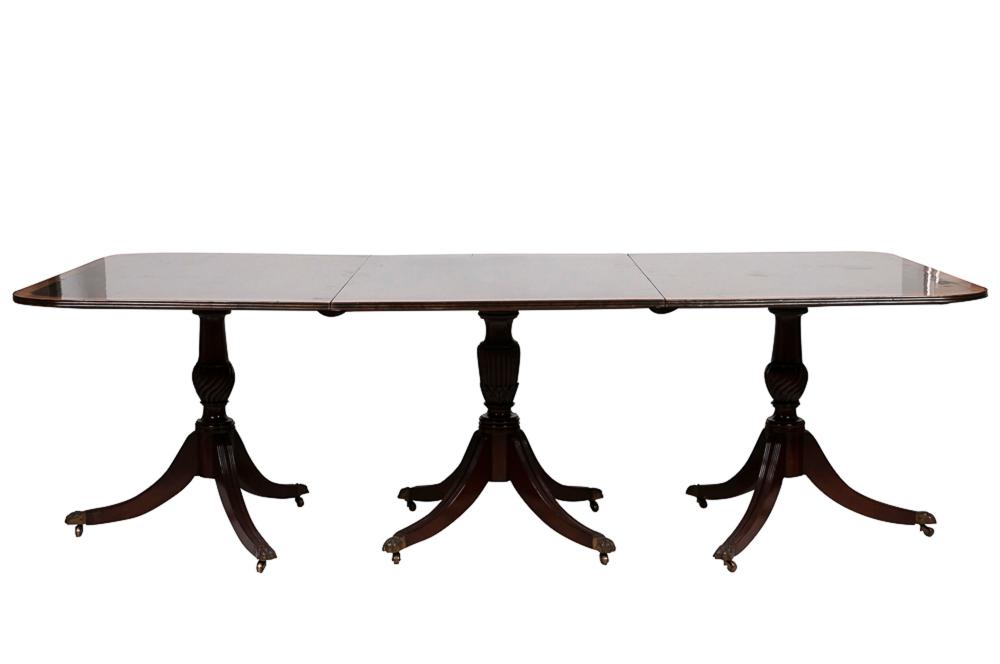 Appraisal: REGENCY STYLE TRIPLE-PEDESTAL MAHOGANY DINING TABLEwith cross banded top and