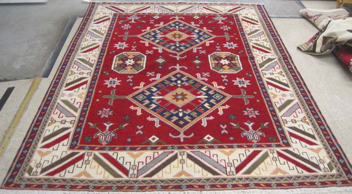 Appraisal: HAND KNOTTED ORIENTAL CARPET Caucasian geometric two-medallion design on red