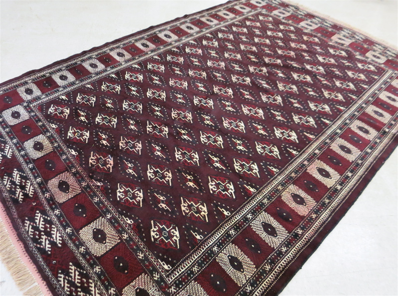 Appraisal: PERSIAN TURKOMAN CARPET repeating rows of geometric Turkoman gols on