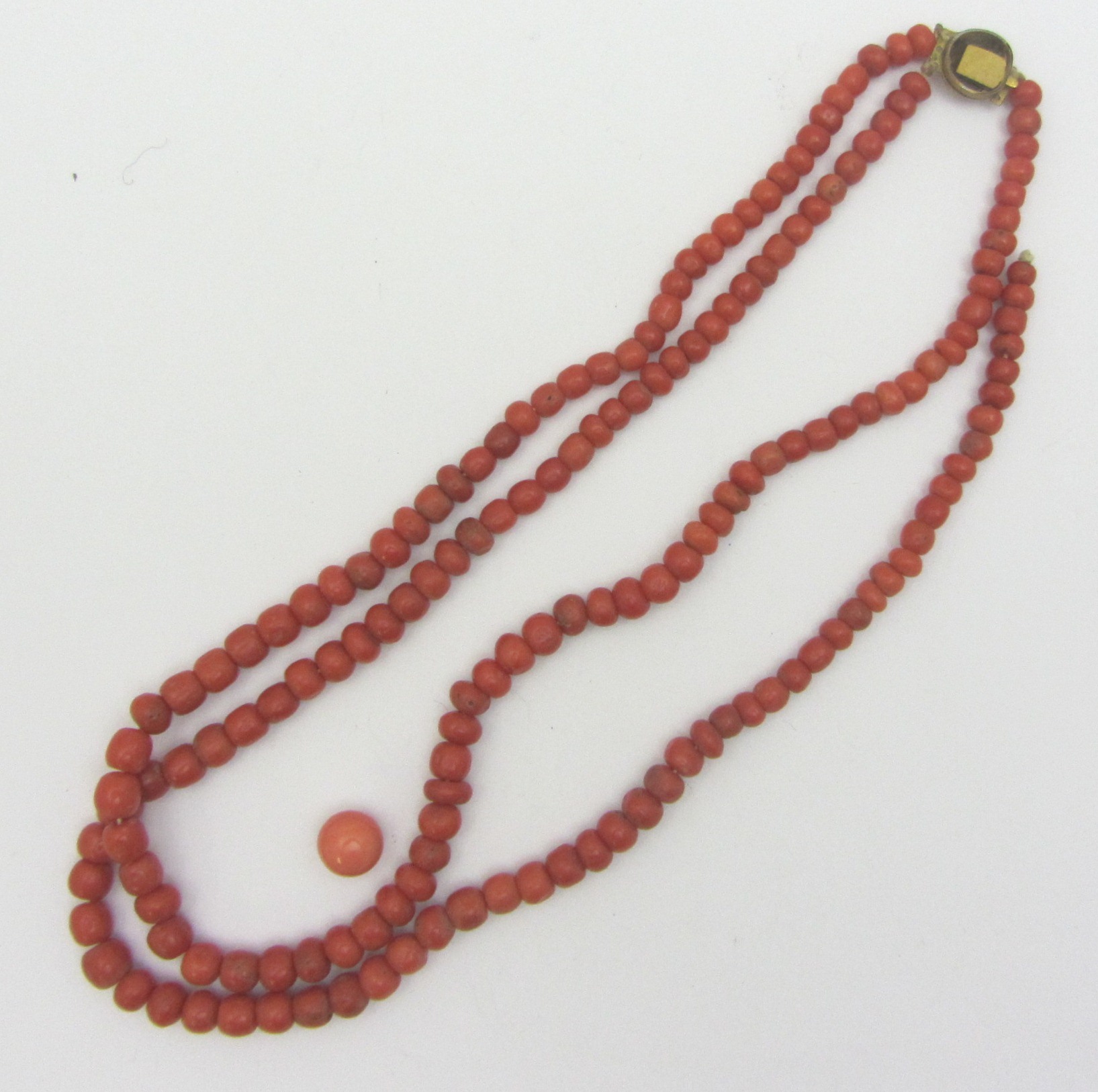 Appraisal: A two row necklace of coral beads on a gilt