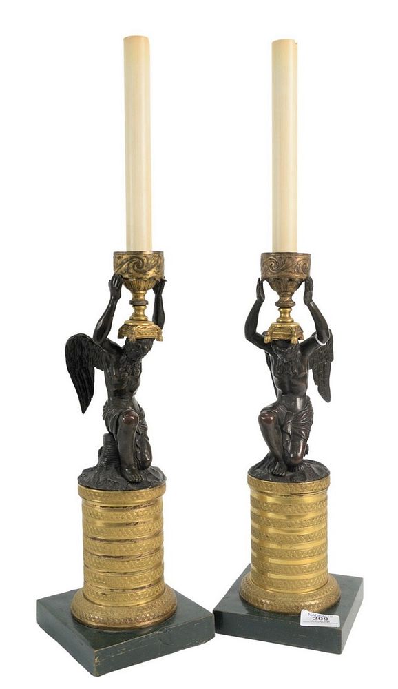 Appraisal: Pair of Bronze Candlesticks having a winged bronze man holding