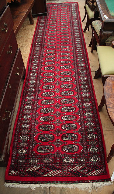 Appraisal: AN EASTERN BOKHARA STYLE RED GROUND RUNNER cm x cm