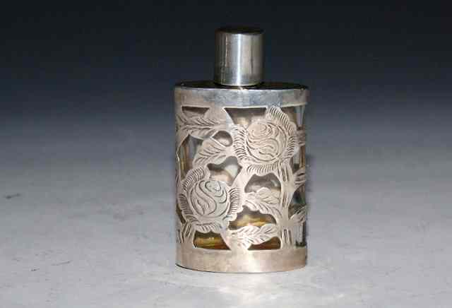 Appraisal: A MEXICAN SILVER OVERLAY AND GLASS SCENT BOTTLE with pierced