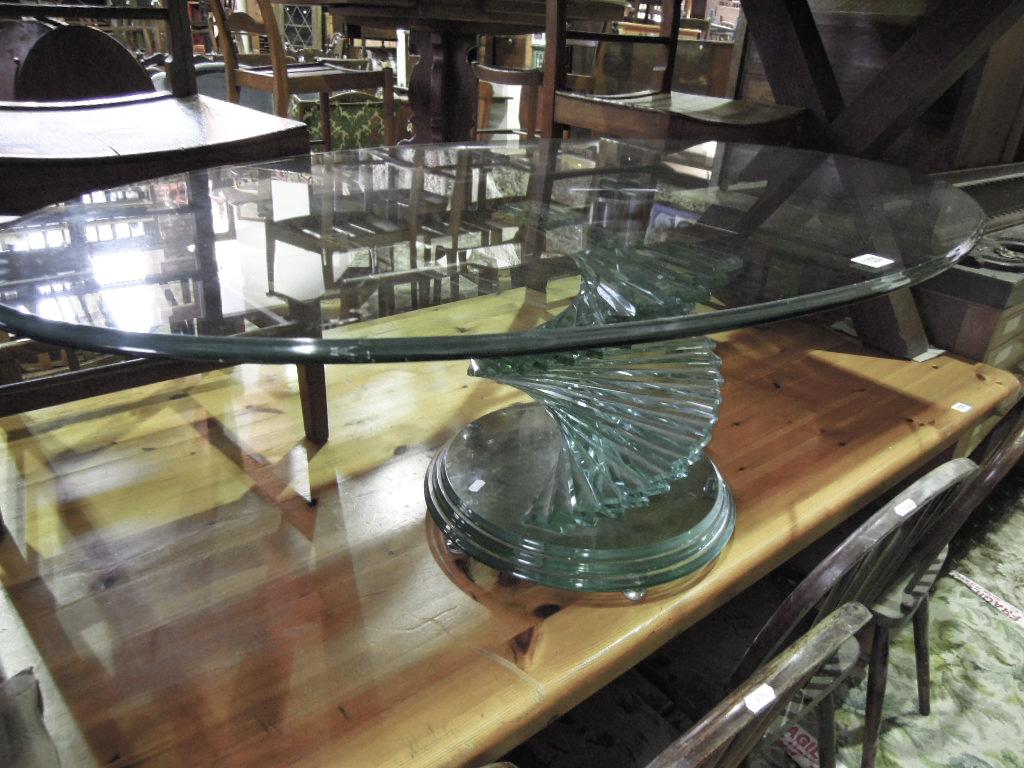 Appraisal: A contemporary glass occasional table of oval form with thumb