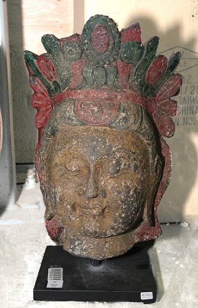 Appraisal: An archaistic carved and painted stone head of Guanyin Displaying